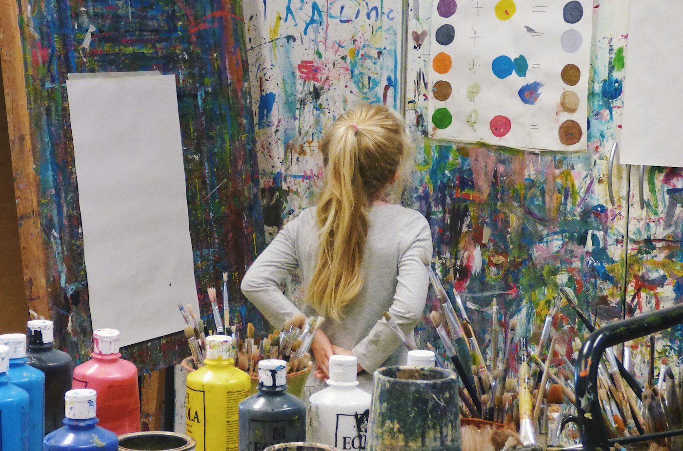 Student working on a painting in a colorful art room